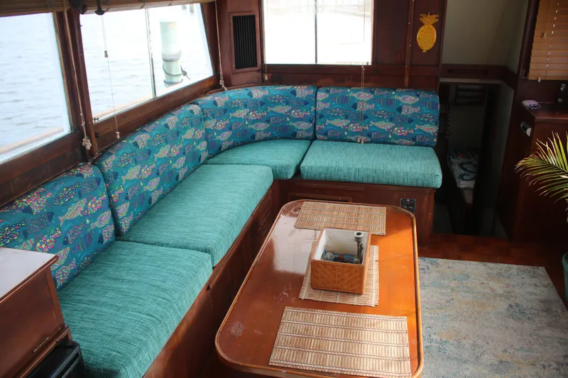 Slide: The Image of 1974 Grand Banks 42 Classic yacht interior with teal seating and wooden table. - 9