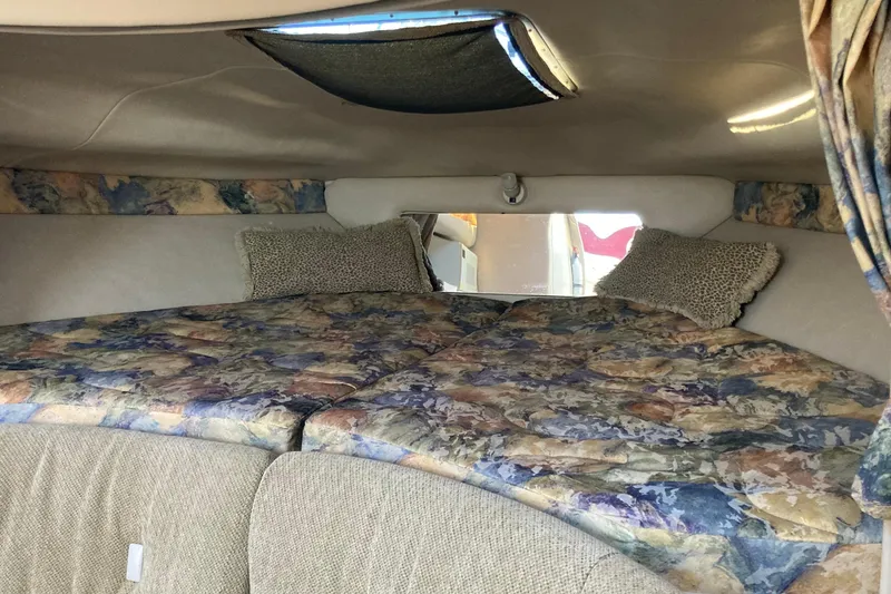 Slide: The Image of Interior cabin of 1999 Chaparral Signature 29 boat with patterned bedding and pillows. - 15