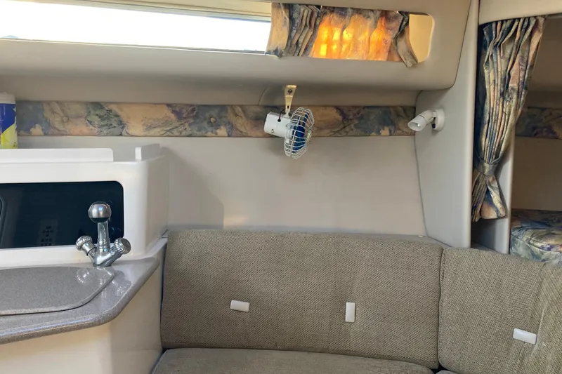 Slide: The Image of 1999 Chaparral Signature 29 boat interior with sink, seating, and curtains. - 20