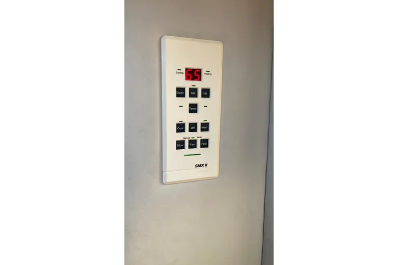 Slide: The Image of Wall-mounted digital thermostat with buttons, displaying temperature, in a 1999 Chaparral Signature 29 boat. - 25