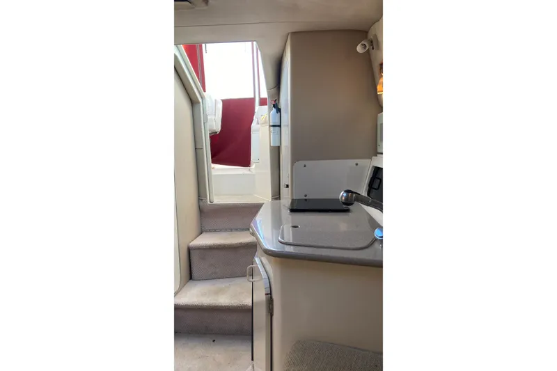 Slide: The Image of Interior view of 1999 Chaparral Signature 29 boat, featuring stairs and kitchenette. - 26