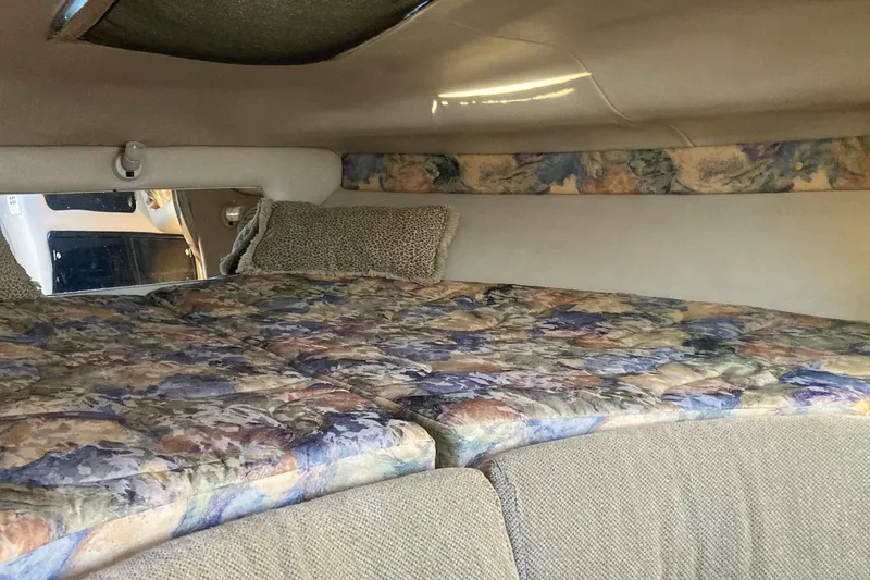 Slide: The Image of Interior cabin of 1999 Chaparral Signature 29 with floral-patterned bedding and cozy decor. - 28