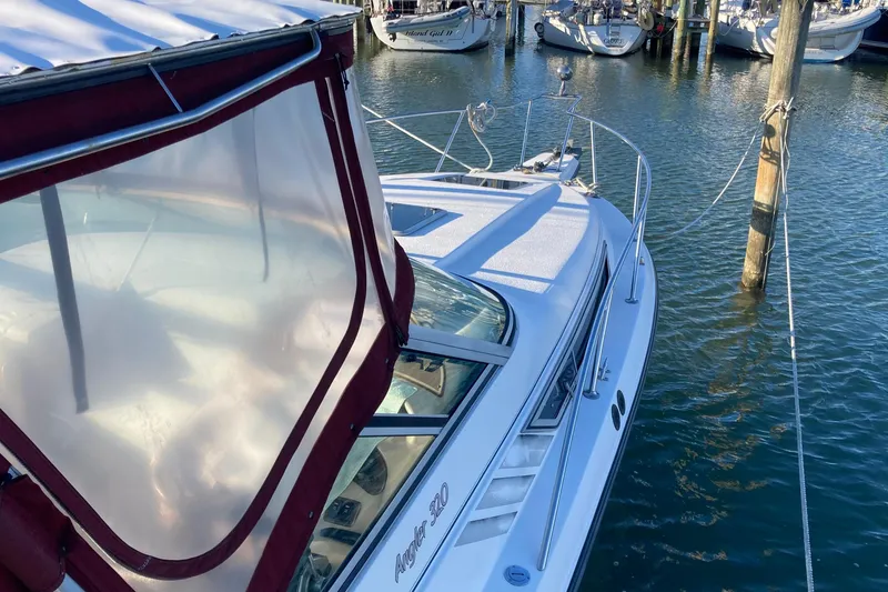 Slide: The Image of 1999 Chaparral Signature 29 boat docked in a marina, featuring a red canopy. - 3