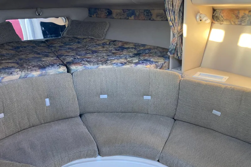 Slide: The Image of 1999 Chaparral Signature 29 cabin interior with cushioned seating and patterned bedding. - 30