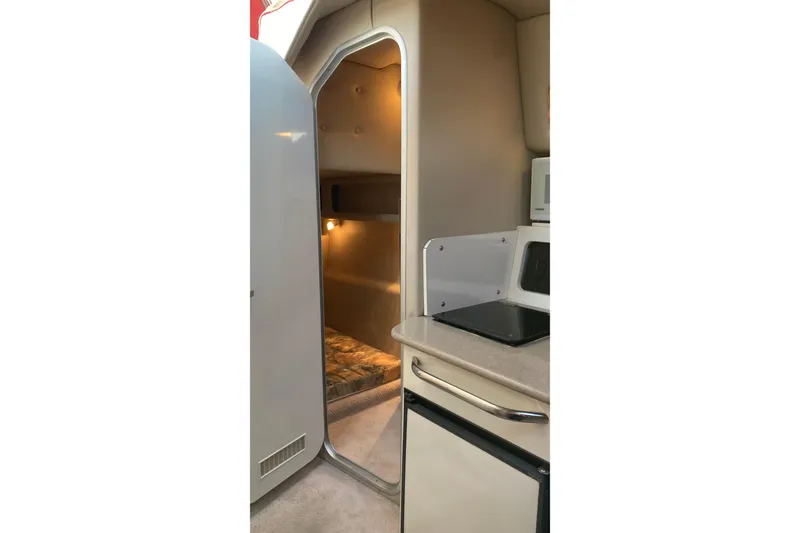 Slide: The Image of Interior of 1999 Chaparral Signature 29 boat, featuring kitchenette and cozy sleeping area. - 35