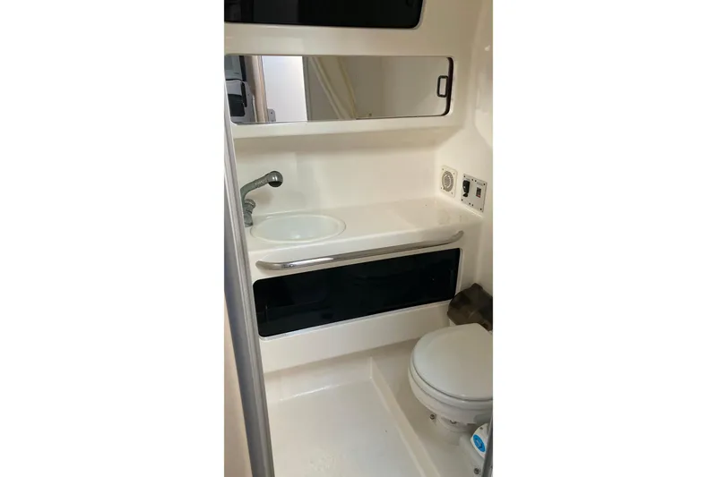 Slide: The Image of 1999 Chaparral Signature 29 boat bathroom with sink, mirror, and toilet. - 38