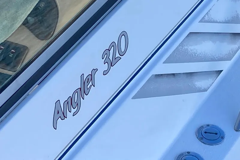 Slide: The Image of Close-up of a 1999 Chaparral Signature 29 boat with "Angler 320" text. - 4