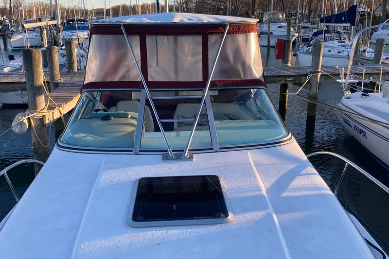 Slide: The Image of 1999 Chaparral Signature 29 boat docked at marina, featuring a covered cockpit area. - 48