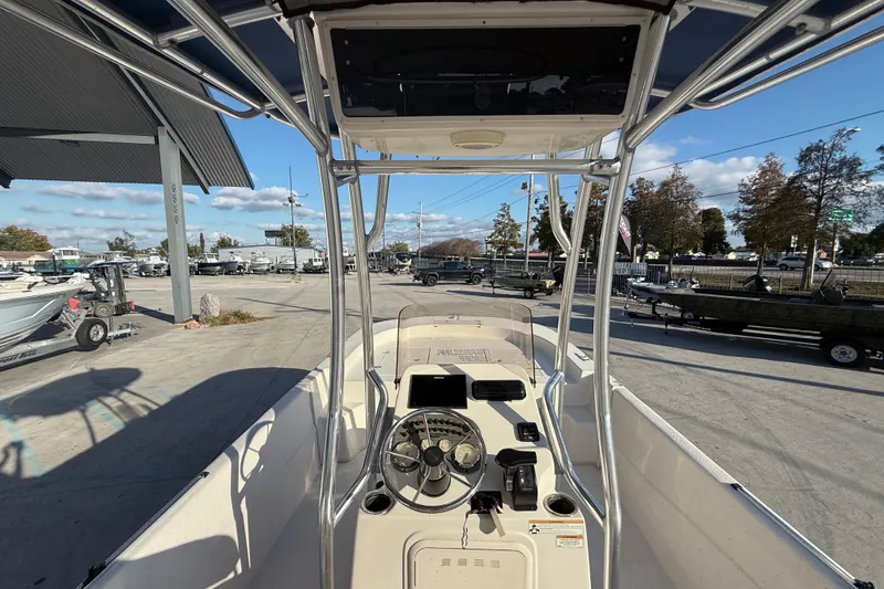 Slide: The Image of 2017 Carolina Skiff 218 boat interior with steering wheel and console, parked outdoors. - 16