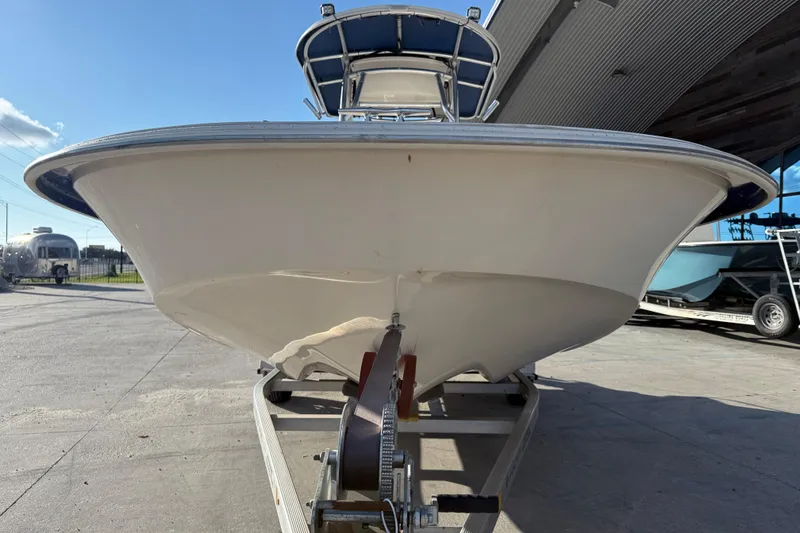 Slide: The Image of 2017 Carolina Skiff 218 boat on trailer, viewed from the front at a marina. - 3