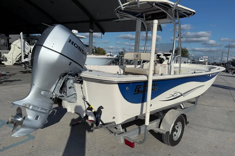 Slide: The Image of 2017 Carolina Skiff 218 boat with Honda outboard motor on trailer, parked outdoors. - 7