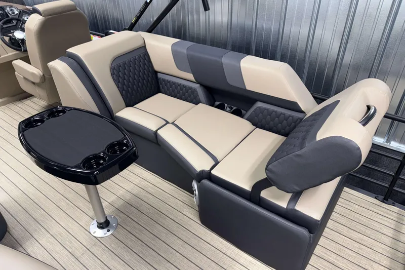 Slide: The Image of 2026 Sylvan L3 LZ boat interior with beige and gray seating, cupholders, and table. - 13