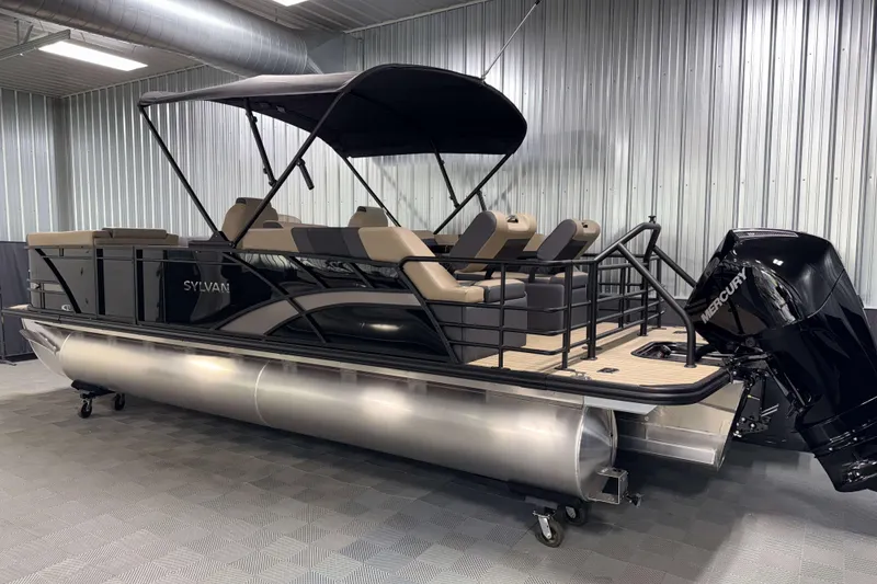 Slide: The Image of 2026 Sylvan L3 LZ pontoon boat with Mercury outboard in a metal-walled showroom. - 26