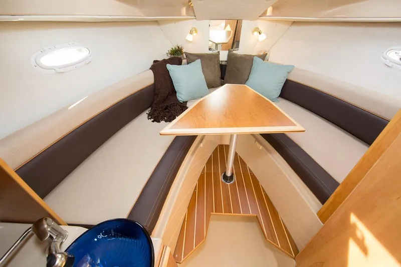 Slide: The Image of 2016 Cutwater C-24 cabin interior with seating, decor, and a small fan. - 9