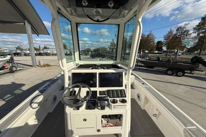 Slide: The Image of 2022 Caymas 28 HB Twin boat console with steering wheel and Raymarine displays. - 19