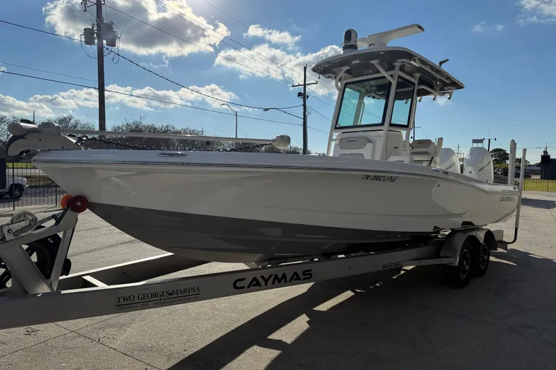 Slide: The Image of 2022 Caymas 28 HB Twin boat on trailer, featuring dual Mercury engines. - 4