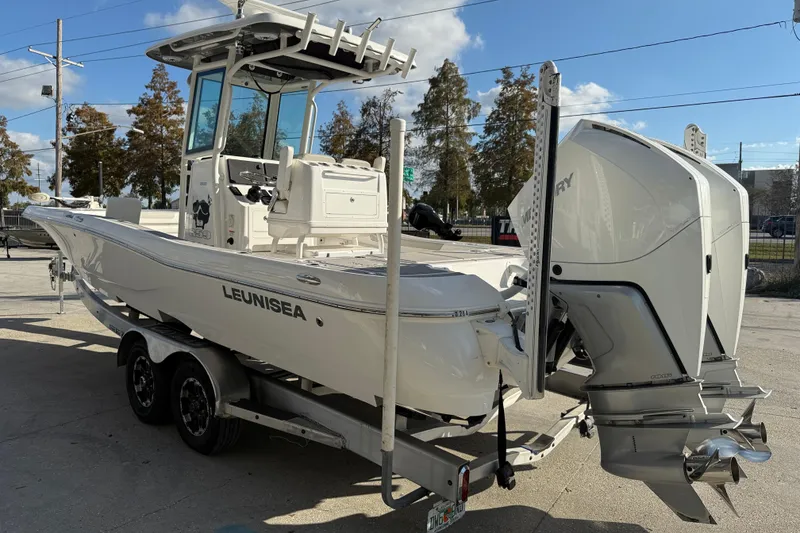 Slide: The Image of 2022 Caymas 28 HB Twin boat with dual outboard engines, parked outdoors. - 5