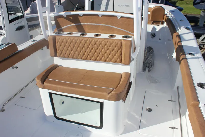 Slide: The Image of 2026 Sea Hunt Ultra 285 SE boat interior with tan cushioned seating and rod holders. - 14