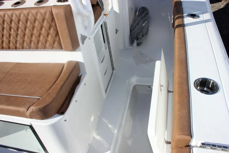 Slide: The Image of 2026 Sea Hunt Ultra 285 SE boat interior with brown cushioned seating and storage compartment. - 17