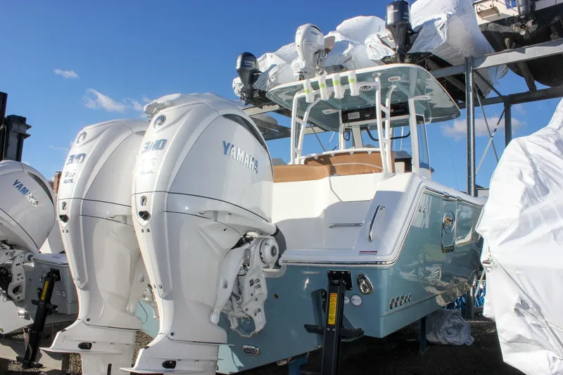 Slide: The Image of 2026 Sea Hunt Ultra 285 SE boat with dual Yamaha engines, docked under clear blue sky. - 2