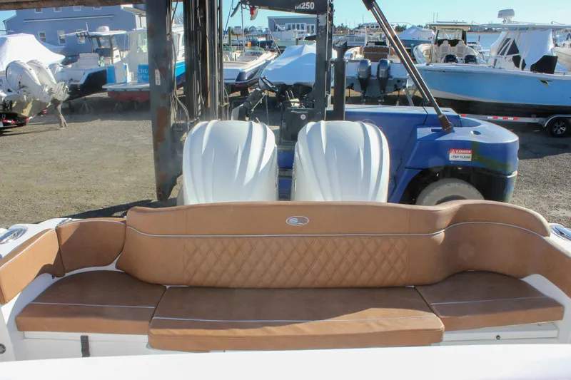 Slide: The Image of 2026 Sea Hunt Ultra 285 SE boat with tan seating and dual engines in a marina setting. - 22