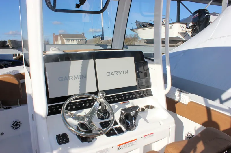 Slide: The Image of 2026 Sea Hunt Ultra 285 SE boat dashboard with Garmin displays and steering wheel. - 31