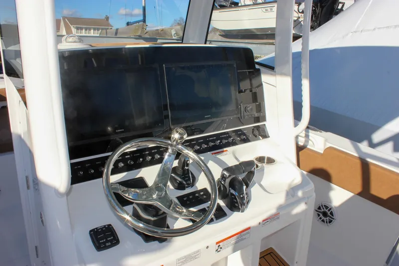 Slide: The Image of 2026 Sea Hunt Ultra 285 SE boat dashboard with steering wheel and dual screens. - 33