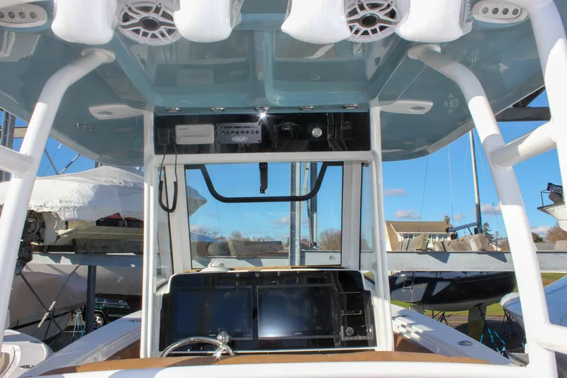 Slide: The Image of 2026 Sea Hunt Ultra 285 SE boat console with electronics and speakers, docked under clear sky. - 35