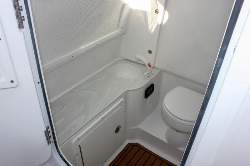 Slide: The Image of 2026 Sea Hunt Ultra 285 SE boat bathroom with compact sink and toilet. - 42