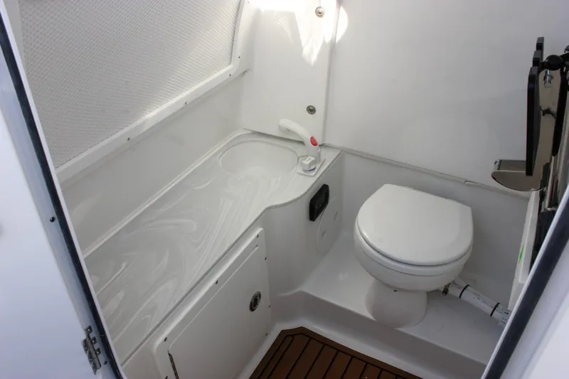 Slide: The Image of 2026 Sea Hunt Ultra 285 SE boat bathroom with toilet and sink. - 45