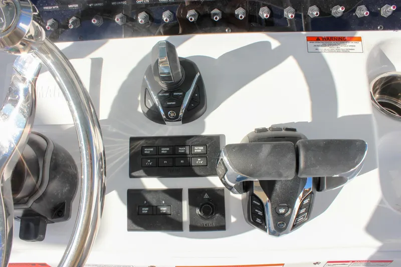 Slide: The Image of Control panel of 2026 Sea Hunt Ultra 285 SE boat with steering and throttle controls. - 49