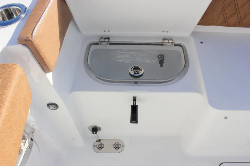 Slide: The Image of 2026 Sea Hunt Ultra 285 SE boat interior with storage compartment and cushioned seating. - 52