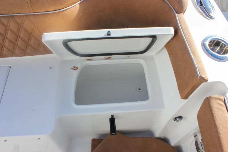 Slide: The Image of Open storage compartment on 2026 Sea Hunt Ultra 285 SE boat with brown seating. - 54
