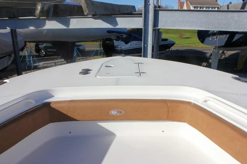 Slide: The Image of 2026 Sea Hunt Ultra 285 SE boat interior with brown seating, docked outdoors. - 60