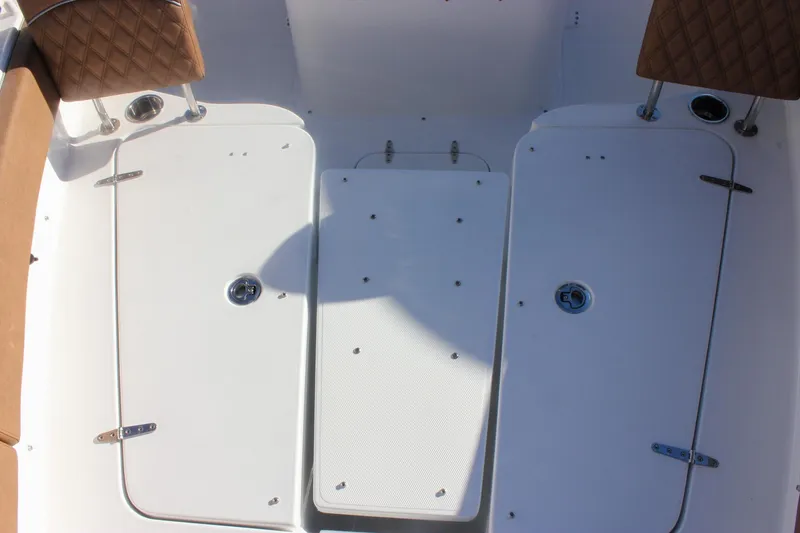 Slide: The Image of 2026 Sea Hunt Ultra 285 SE boat interior with storage compartments and cushioned seating. - 65