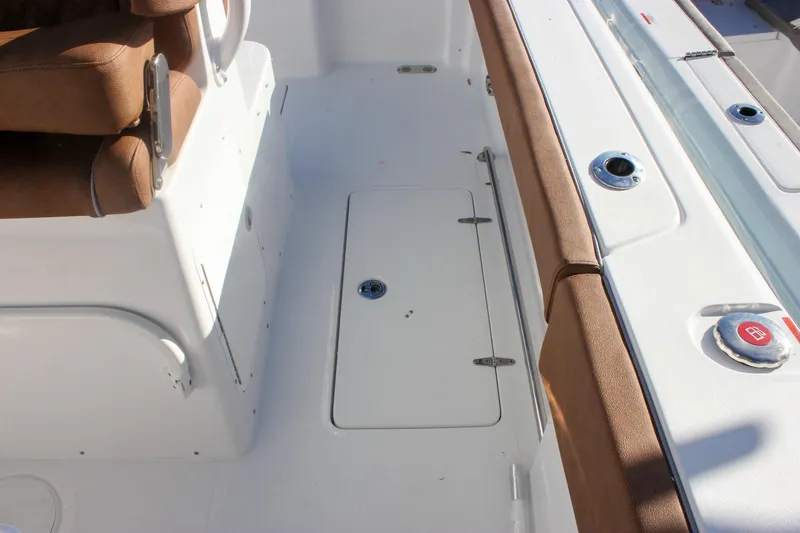 Slide: The Image of 2026 Sea Hunt Ultra 285 SE boat interior with brown seating and storage compartment. - 68