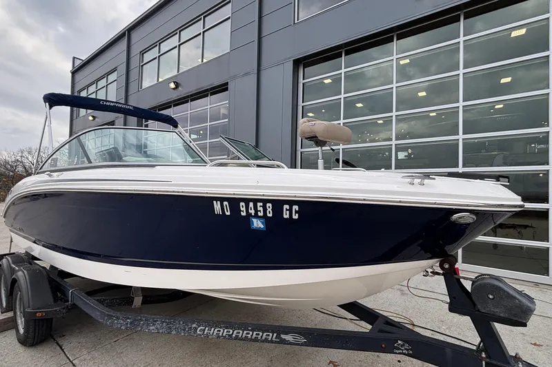 Slide: The Image of 2016 Chaparral 210 Suncoast Ski & Fish boat on trailer, parked outside a modern building. - 14