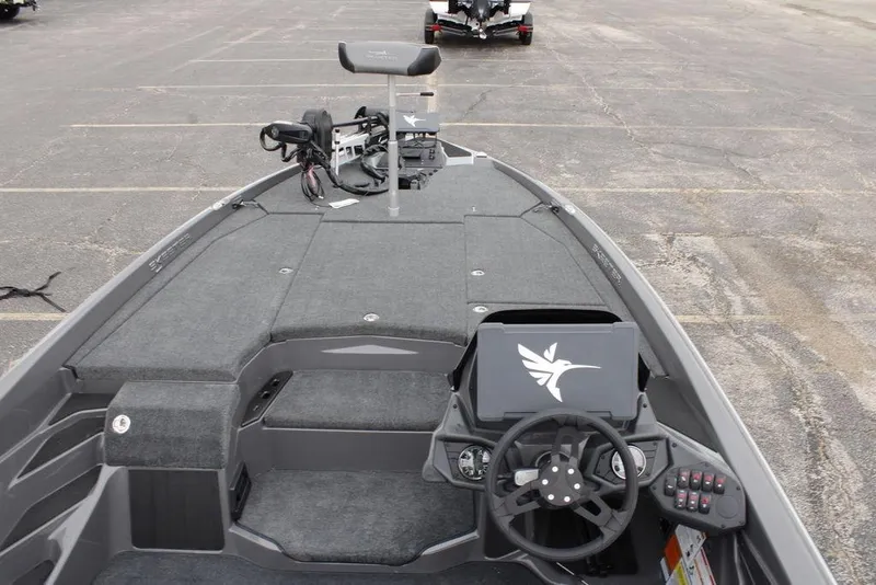 Slide: The Image of 2026 Skeeter ZXE20 boat interior with steering wheel and control panel in a parking lot. - 15