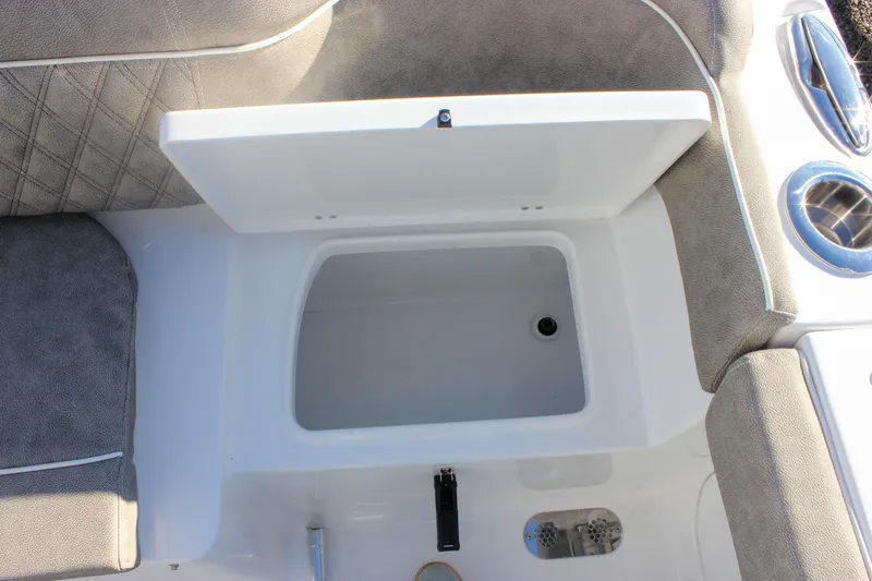 Slide: The Image of Open storage compartment on 2026 Sea Hunt Ultra 265 SE boat with cushioned seating. - 16