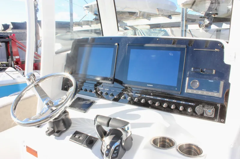 Slide: The Image of 2026 Sea Hunt Ultra 265 SE boat dashboard with steering wheel and electronic displays. - 28