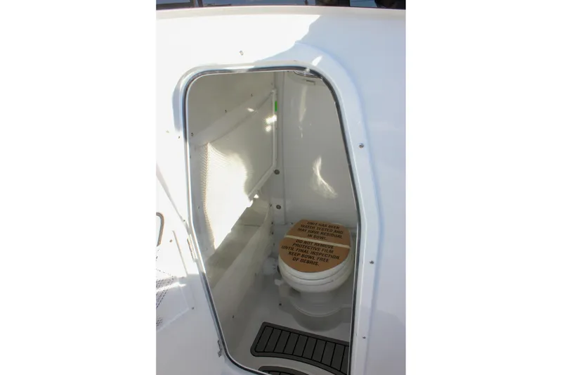 Slide: The Image of 2026 Sea Hunt Ultra 265 SE boat interior with compact marine toilet. - 43