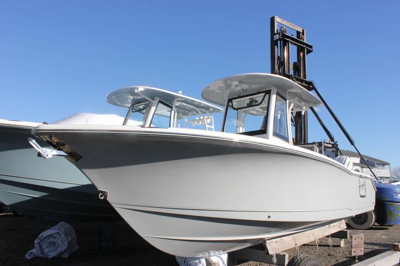 Slide: The Image of 2026 Sea Hunt Ultra 265 SE boat on display under clear blue sky. - 66