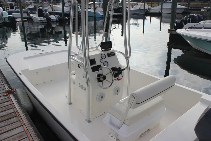 Slide: The Image of 2014 Key West 177 Skiff boat docked at marina, featuring center console and seating. - 13