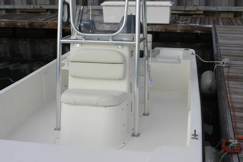 Slide: The Image of 2014 Key West 177 Skiff boat docked, featuring a central console and seating. - 16