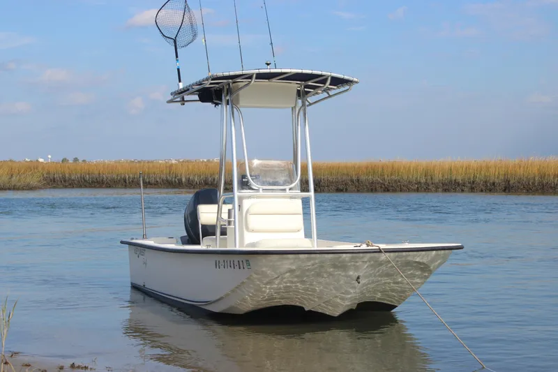 Slide: The Image of 2014 Key West 177 Skiff boat anchored in calm waters with fishing gear. - 2
