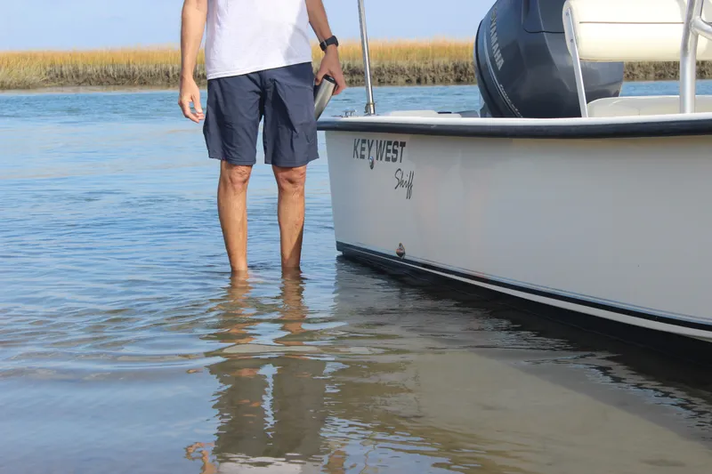 Slide: The Image of Man standing beside 2014 Key West 177 Skiff in shallow water. - 9
