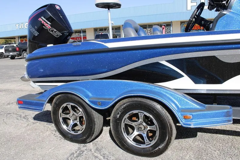 Slide: The Image of Blue 2019 Nitro Z20 boat on trailer with dual wheels, parked outdoors. - 6