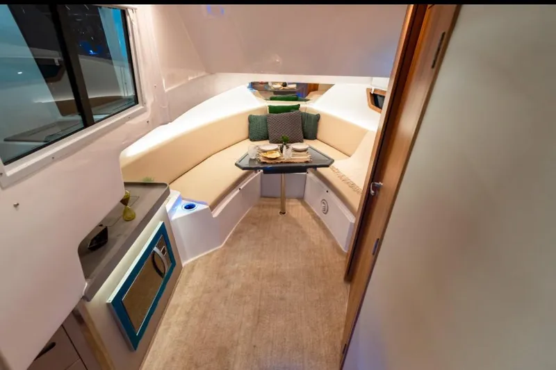 Slide: The Image of Luxurious seating area on 2026 Granfort 37 GTX yacht with striped cushions and wooden table. - 15