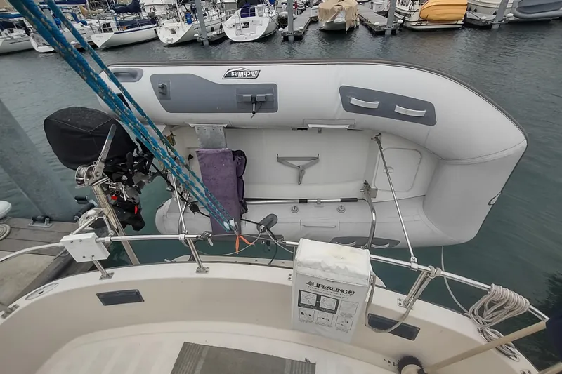 Slide: The Image of Nordic Tug 32 (1990) with dinghy and motor at marina dock. - 11