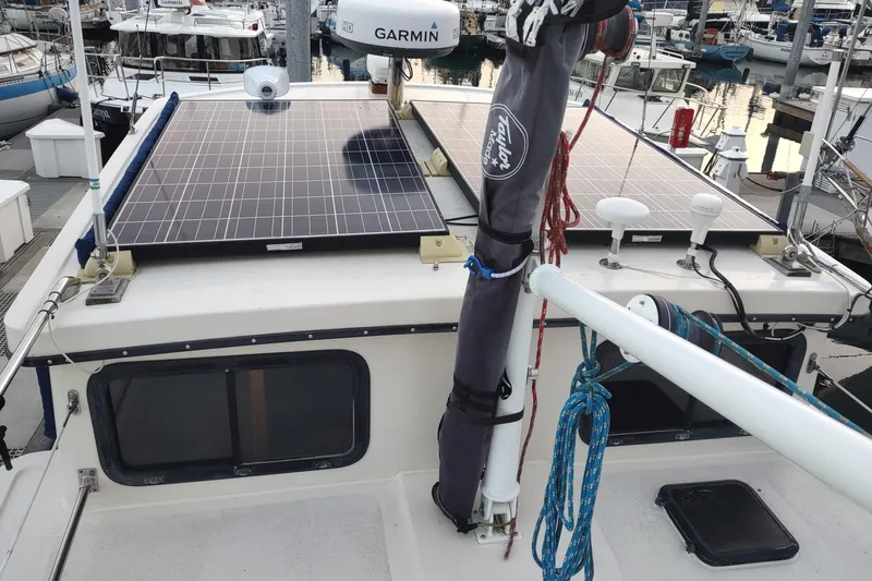 Slide: The Image of 1990 Nordic Tug 32 with solar panels and Garmin equipment at a marina. - 12